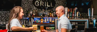 A couple sit at a bar 