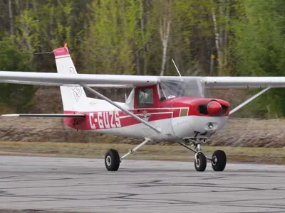 A small red and white airplane on a runway