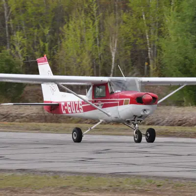 A small red and white airplane on a runway