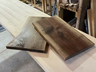 Two polished charcuterie boards sit on a workbench