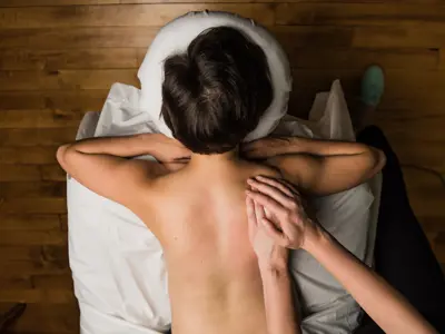 A woman lies on a massage table