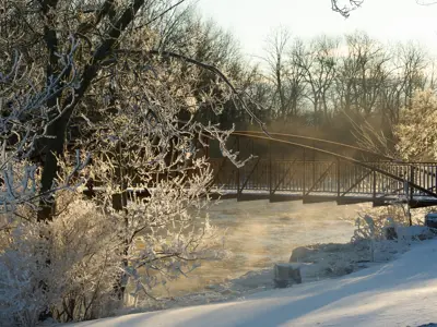 A bridge crossing a small creek in a frosty winter landscape