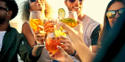 Group of friends clinking glasses of summer drinks