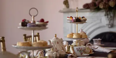 Table set for afternoon tea with silver tiers of sandwiches and pastries