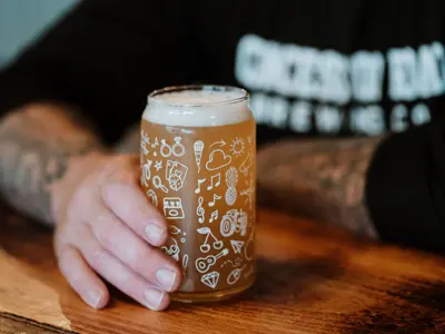 Hand holding a beer on a pub table