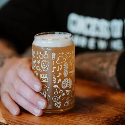 Hand holding a beer on a pub table