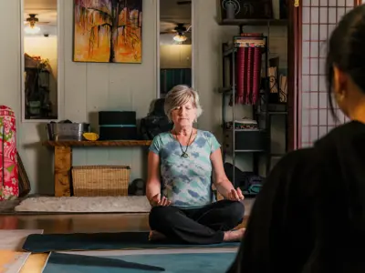 A woman sits on the floor in meditation