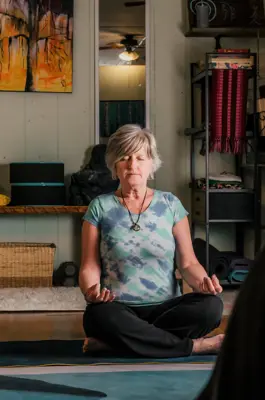 A woman sits on the floor in meditation