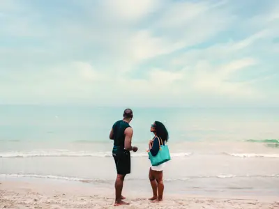 A couple look out across Lake Erie on a sandy beach