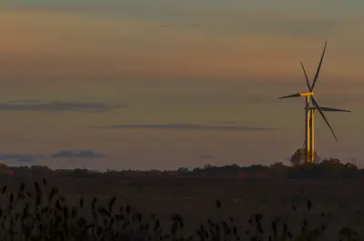 Two windmills churn in the background of a country sunset