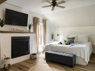 A bedroom in an inn featuring wood floors and white plank boards 